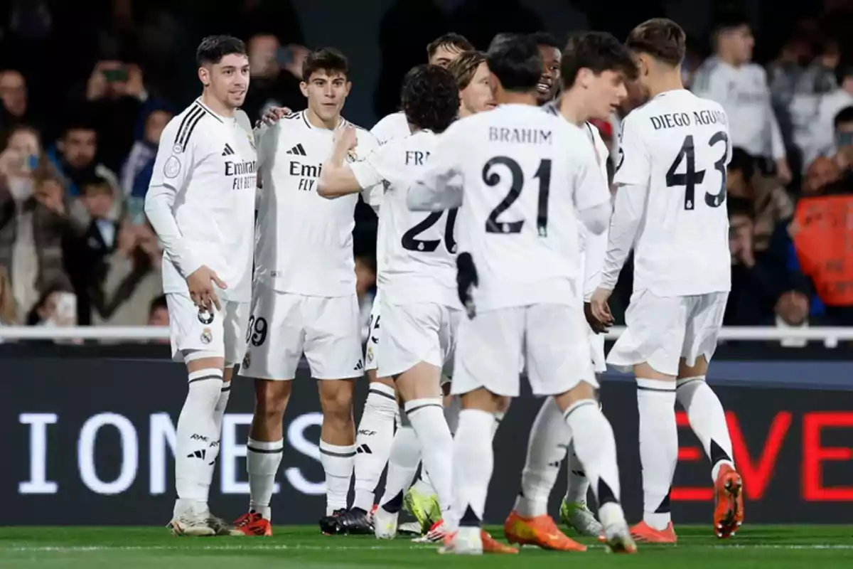 Jugadores de fútbol del Real Madrid celebrando en el campo durante un partido.