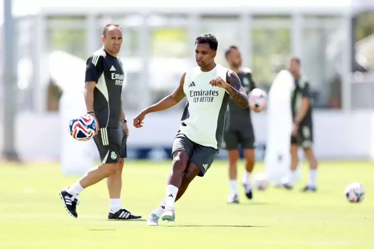 Soccer players training on a grass field in Real Madrid training uniforms while one of them kicks a ball and the others watch. Soccer players training on a grass field in Real Madrid training uniforms while one of them kicks a ball and the others watch.