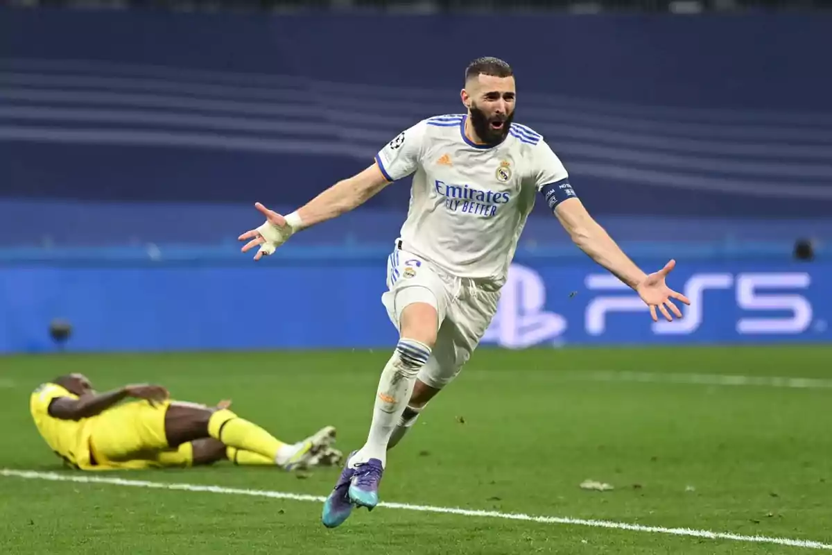 A player celebrates a goal while another player lies on the ground in the background.