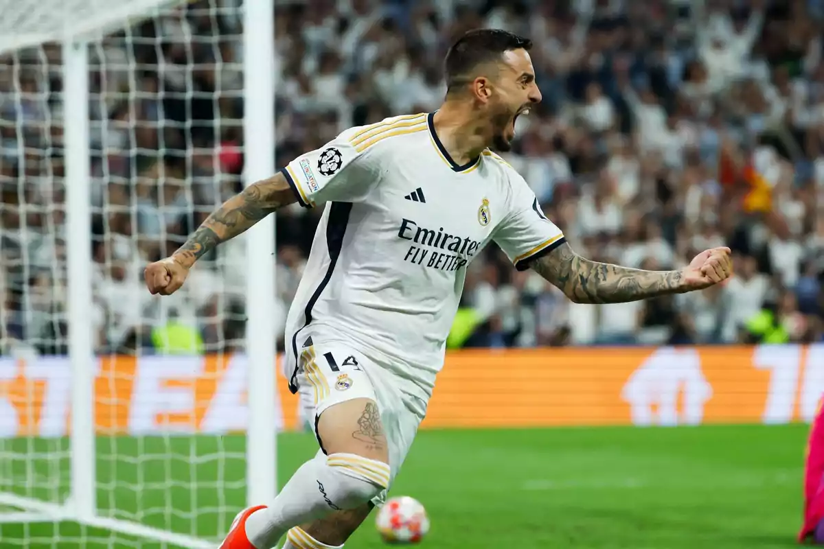 Un jugador de fútbol celebrando un gol en un estadio lleno de espectadores.