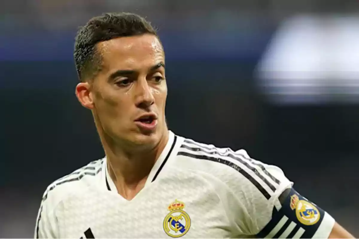 Un jugador de fútbol con uniforme blanco y negro del Real Madrid en el campo de juego.