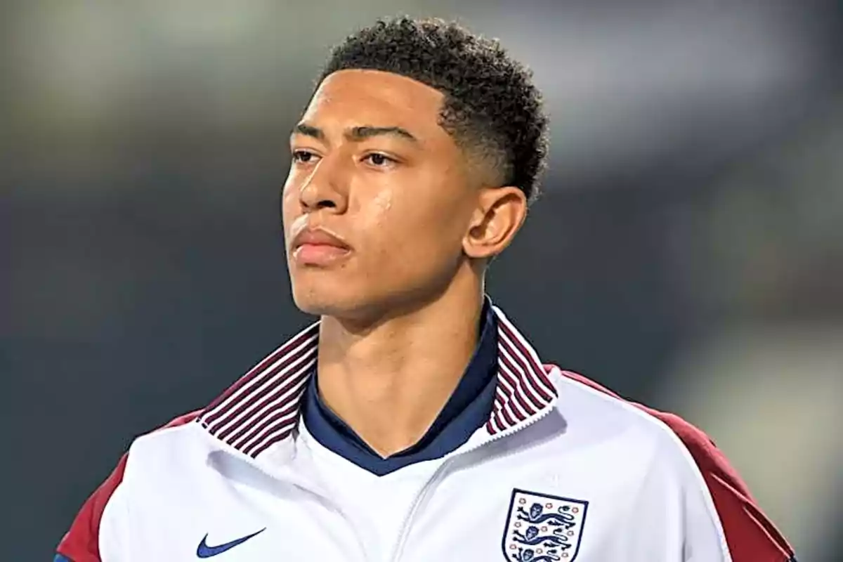 Young footballer wearing a white England team jacket looking toward the horizon Young footballer wearing a white England team jacket looking toward the horizon