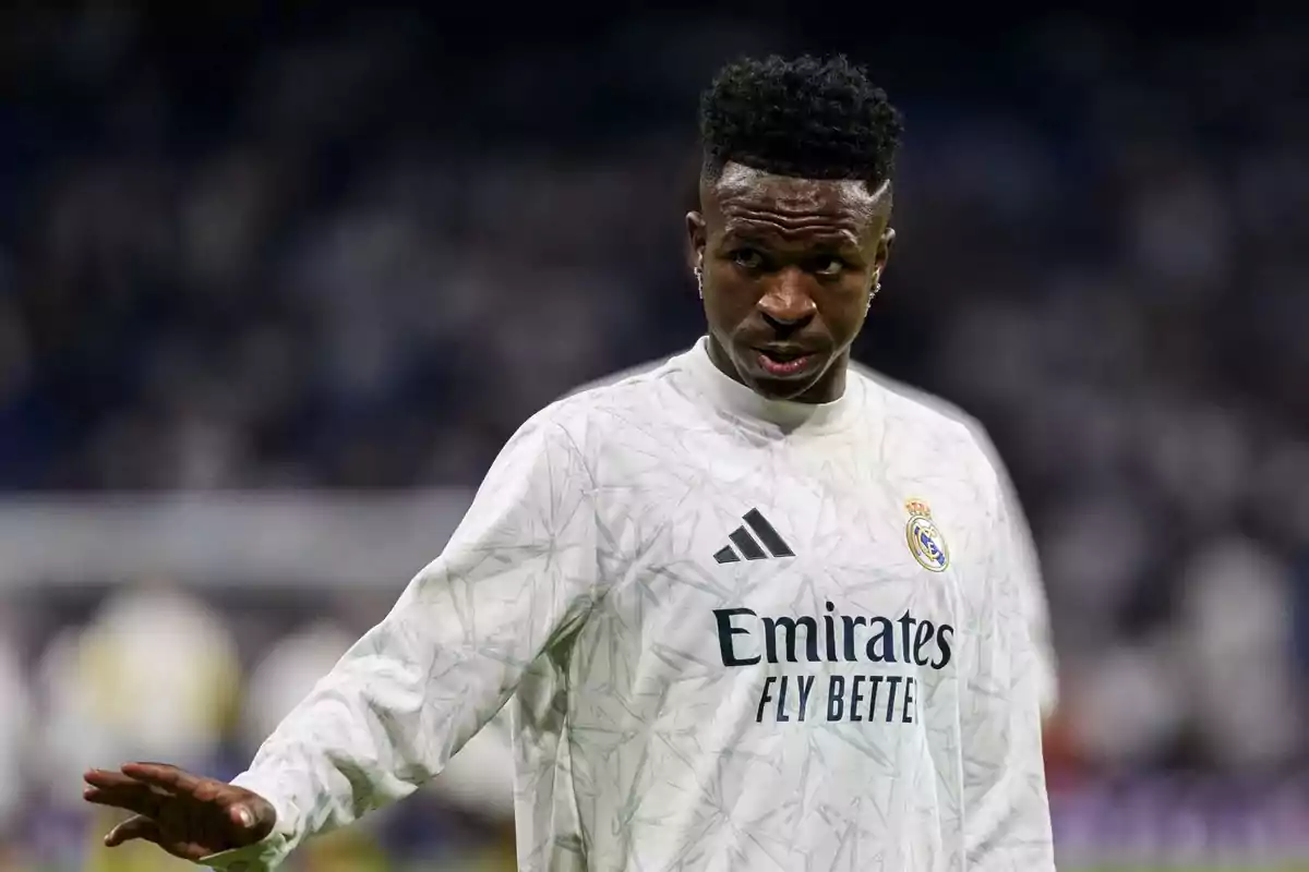 Jugador de fútbol con uniforme blanco del Real Madrid en el campo.