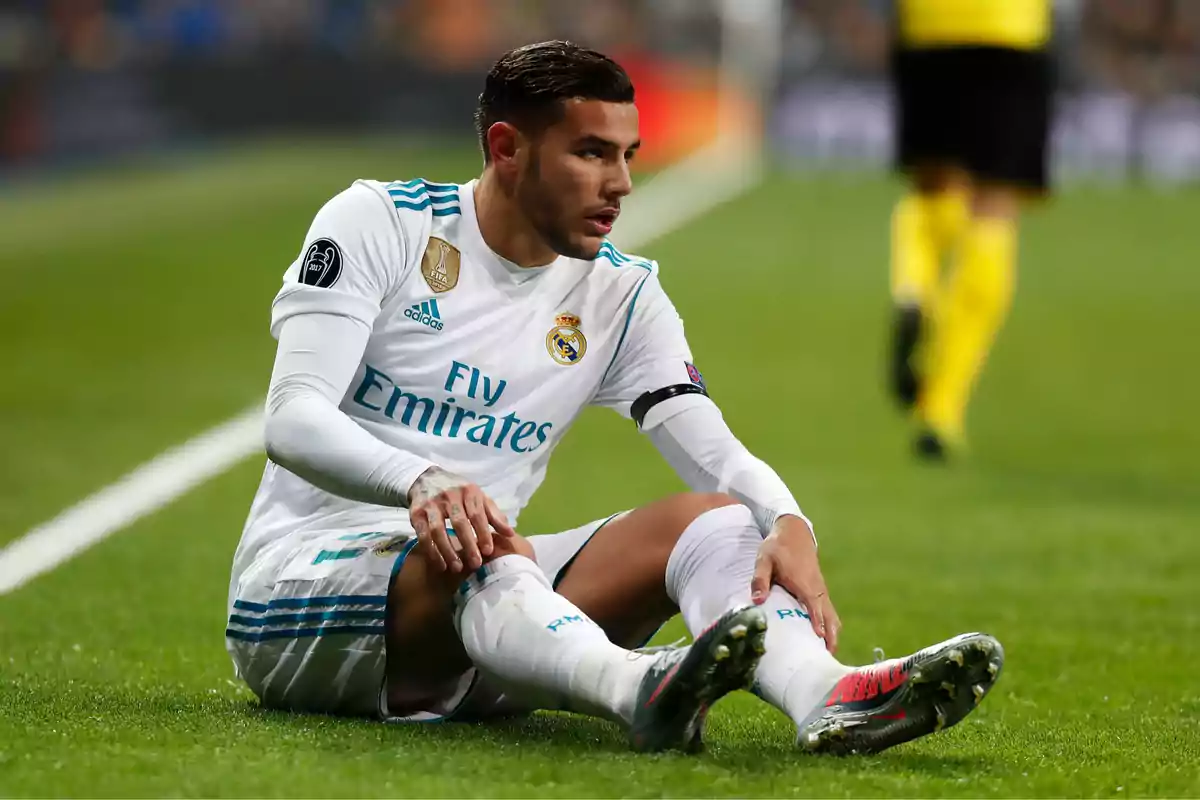 Jugador de fútbol sentado en el campo durante un partido.