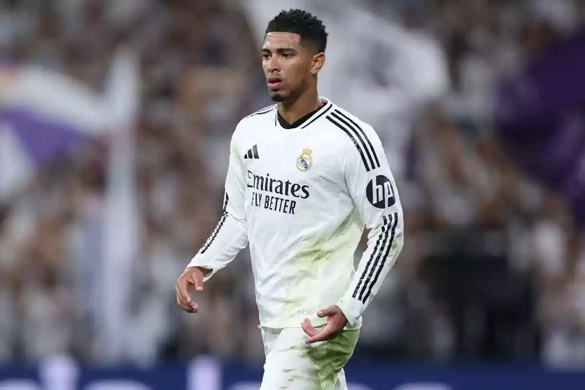 Football player in white Real Madrid uniform on the playing field.