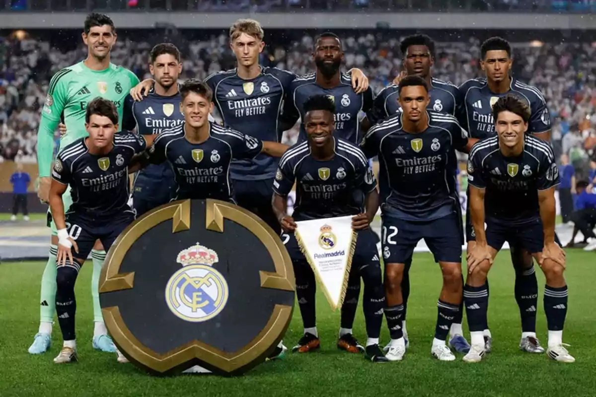 Real Madrid players pose on the field before a match wearing navy blue uniforms and displaying the club crest. Real Madrid players pose on the field before a match wearing navy blue uniforms and displaying the club crest.