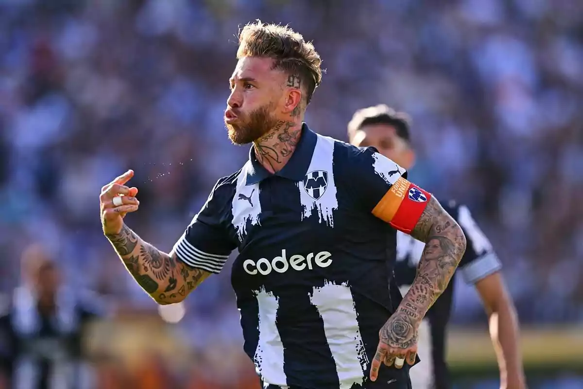 Futbolista tatuado con uniforme de Rayados de Monterrey celebrando en la cancha durante un partido Futbolista tatuado con uniforme de Rayados de Monterrey celebrando en la cancha durante un partido