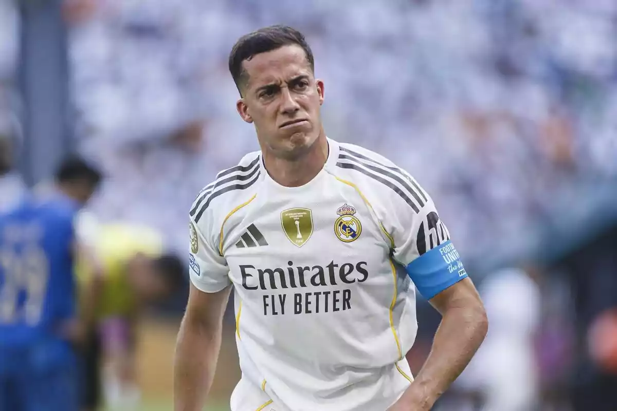 Real Madrid player with a serious expression wearing the team’s white uniform and a blue armband on his left arm during a match