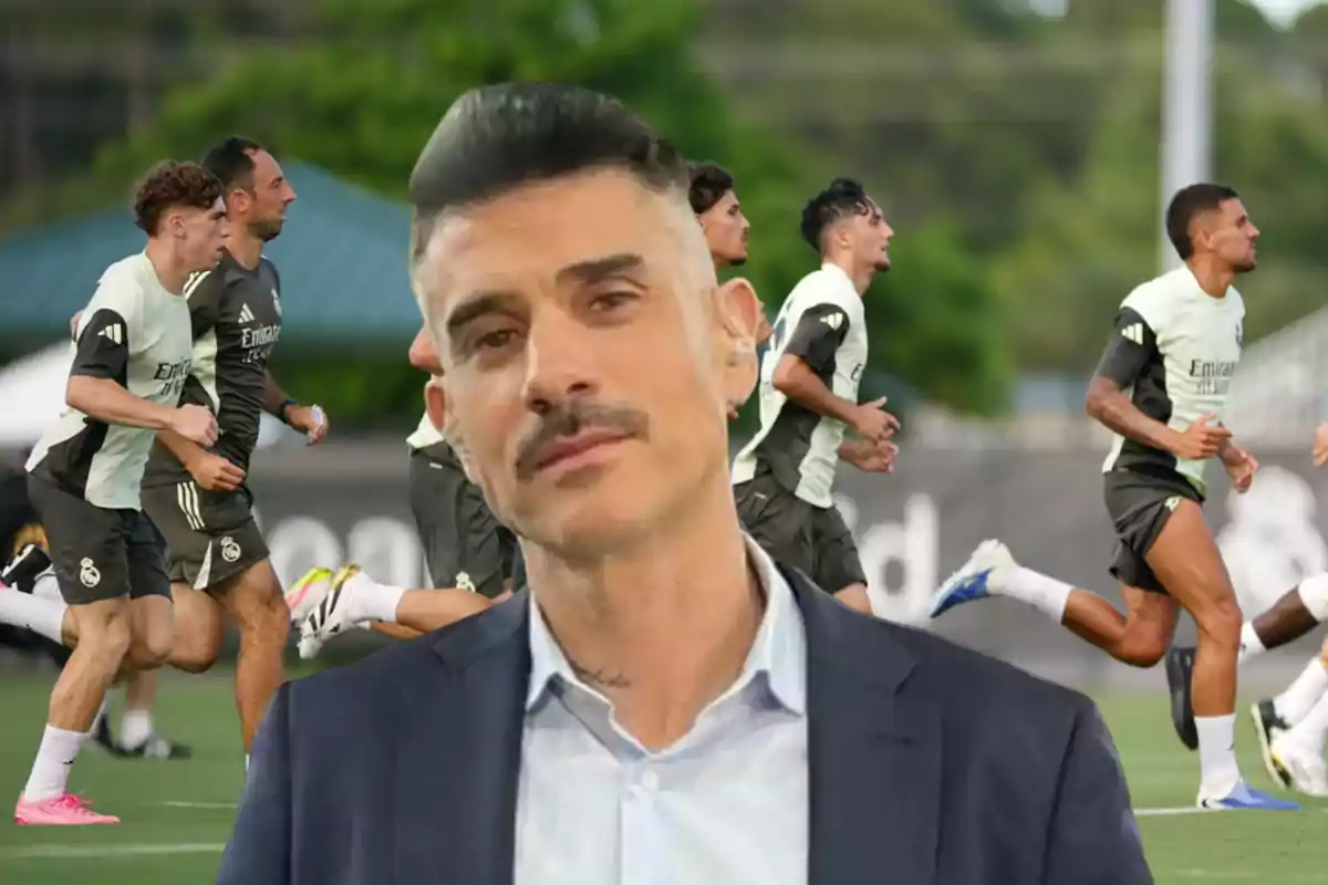 Short-haired man with a mustache in the foreground with players training in the background