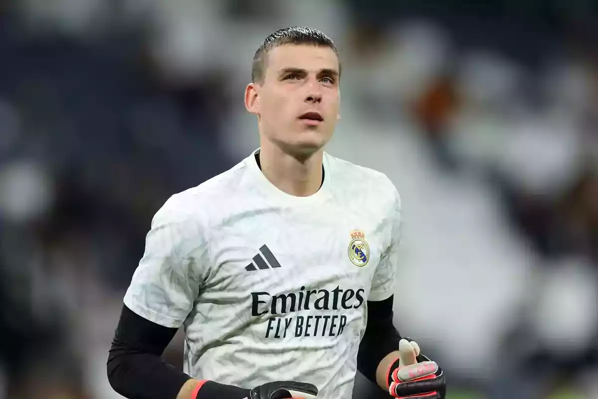 Portero del Real Madrid con uniforme blanco y guantes durante un partido