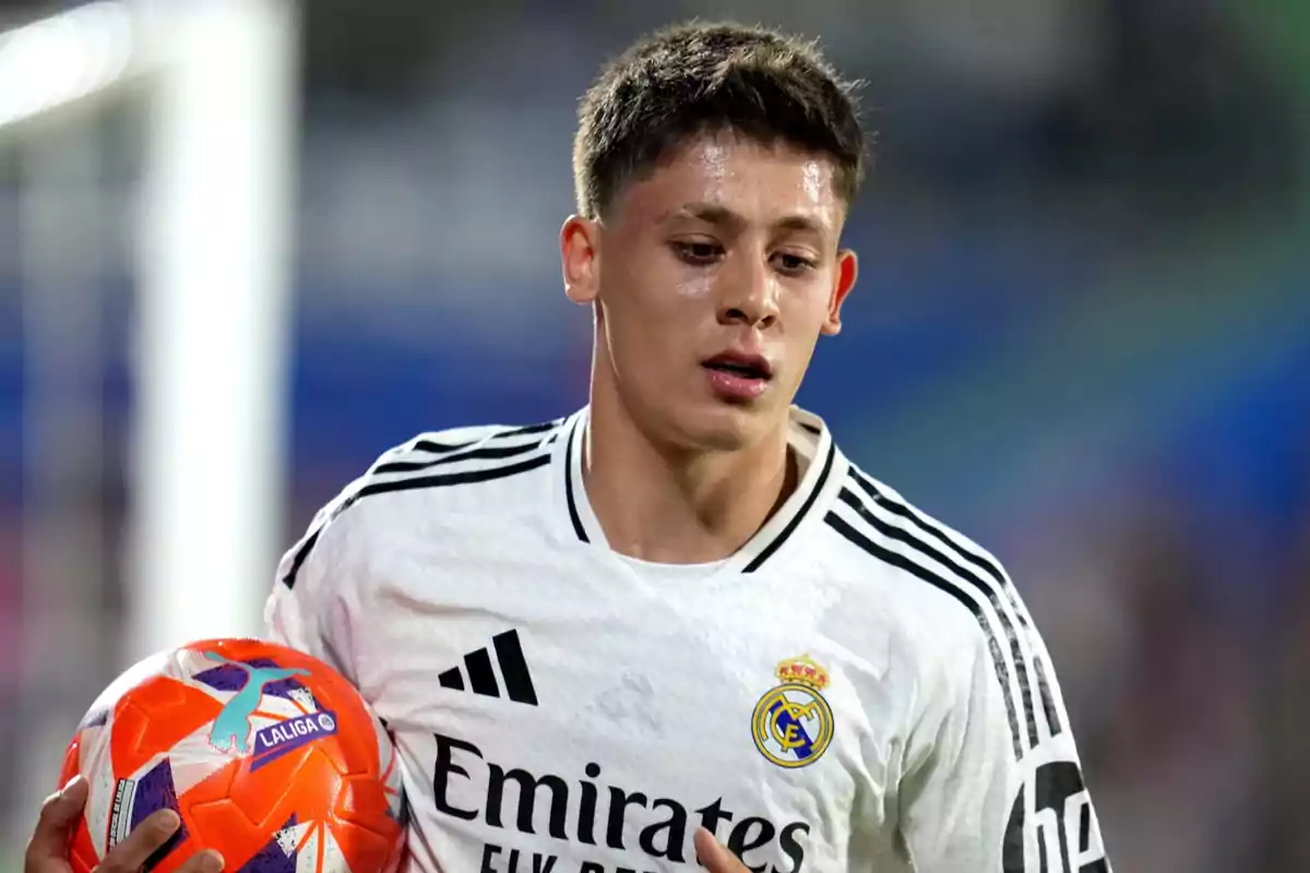 Joven futbolista del Real Madrid sosteniendo un balón durante un partido Joven futbolista del Real Madrid sosteniendo un balón durante un partido