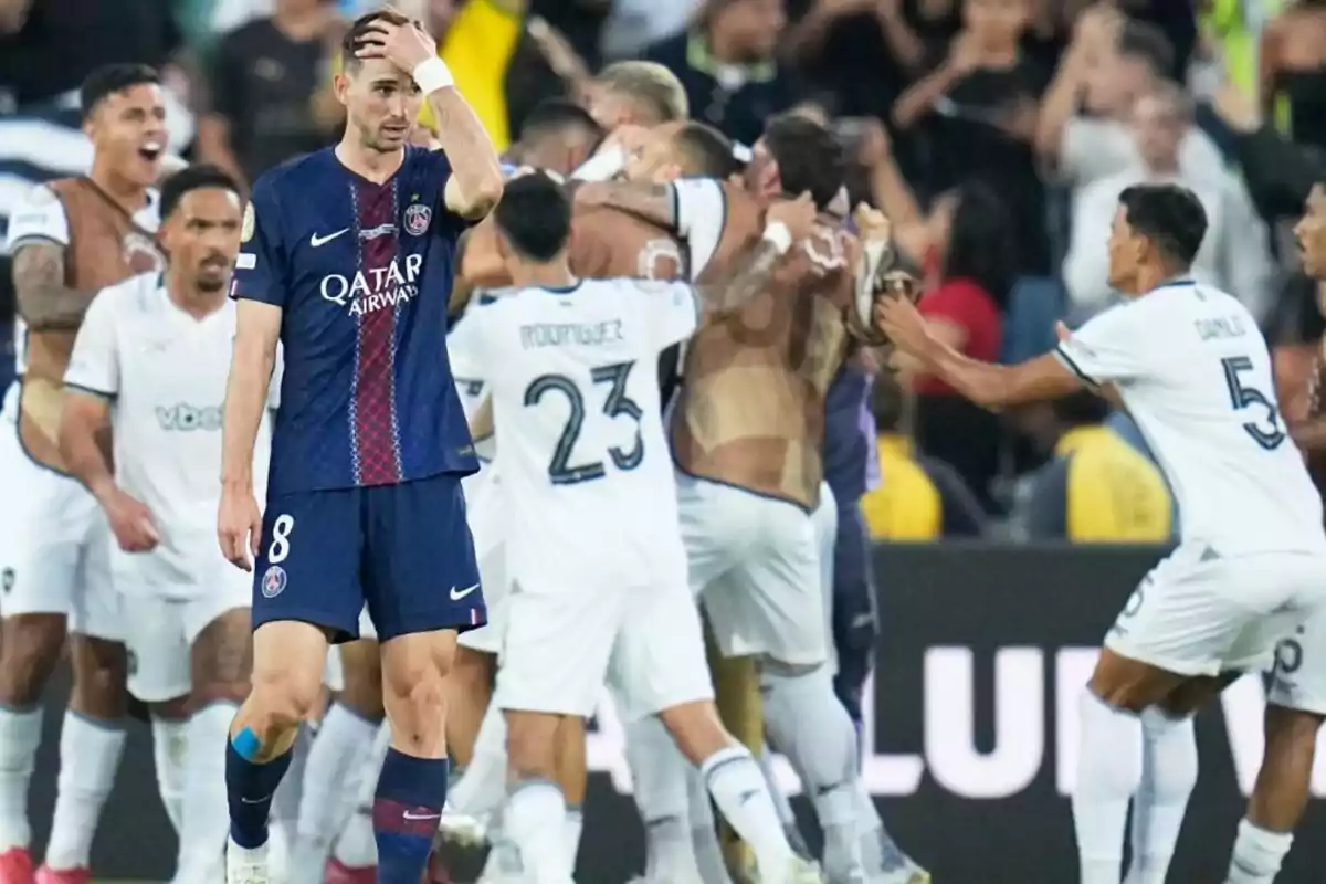 Un jugador del PSG luce decepcionado mientras futbolistas del equipo rival celebran efusivamente en el fondo Un jugador del PSG luce decepcionado mientras futbolistas del equipo rival celebran efusivamente en el fondo