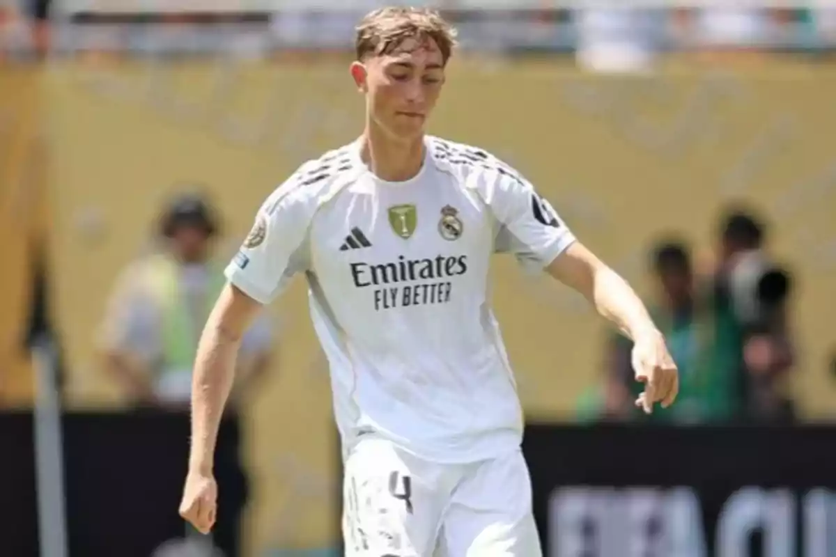 Soccer player wearing Real Madrid’s white uniform on the field during a match Soccer player wearing Real Madrid’s white uniform on the field during a match
