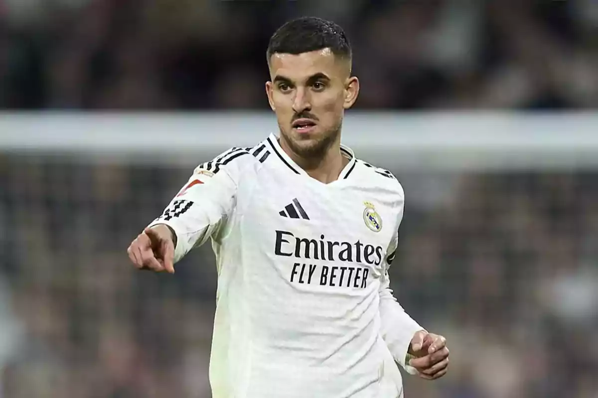 Futbolista del Real Madrid con uniforme blanco señalando con la mano durante un partido Futbolista del Real Madrid con uniforme blanco señalando con la mano durante un partido