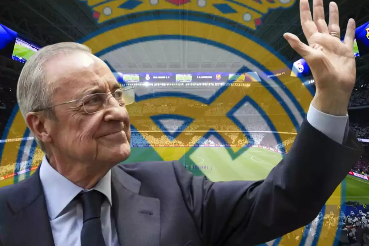 Hombre mayor con gafas y traje saludando en un estadio de fútbol con el escudo del Real Madrid de fondo