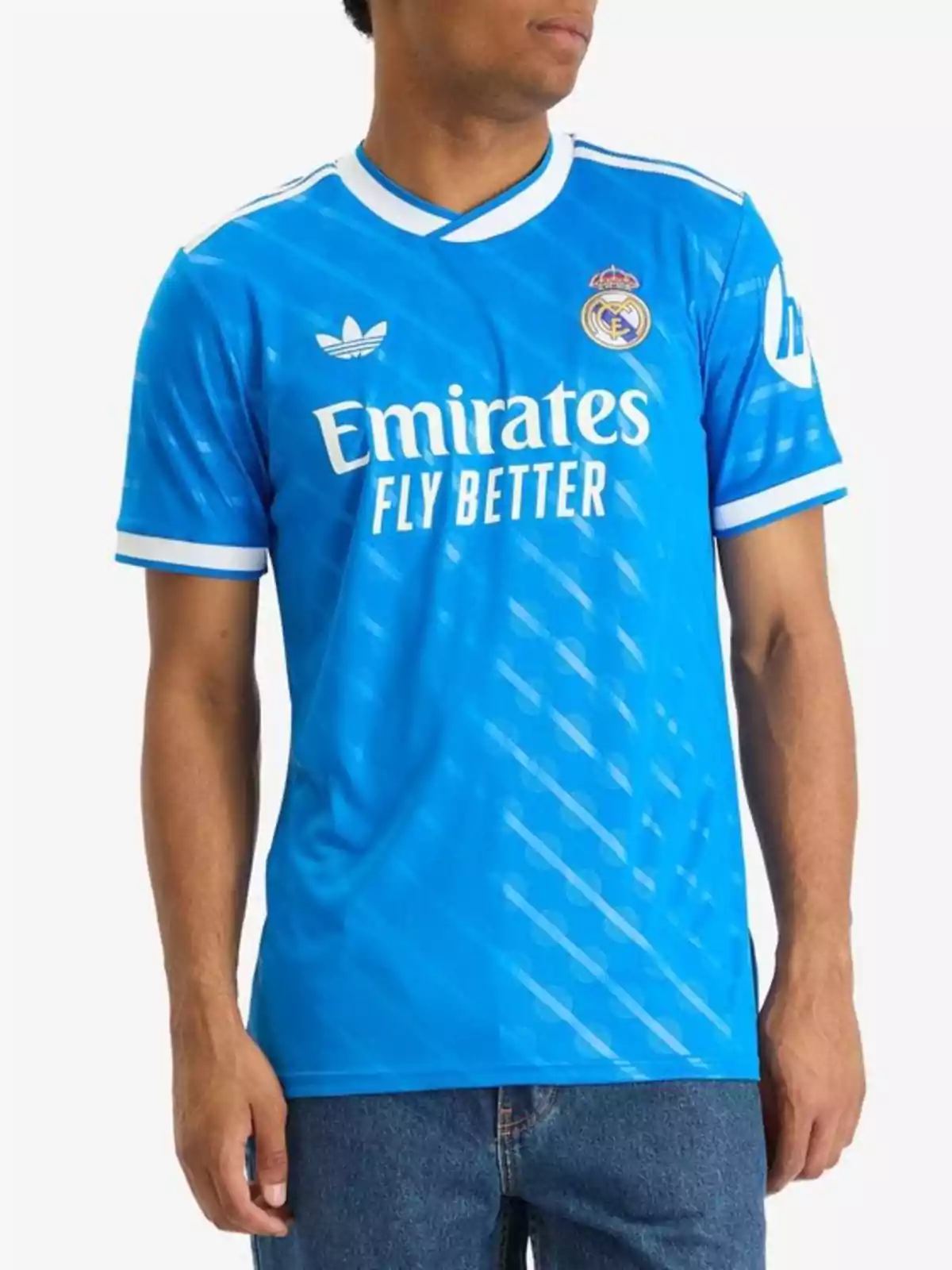 Person wearing a blue Real Madrid jersey with white details and the Emirates Fly Better logo Person wearing a blue Real Madrid jersey with white details and the Emirates Fly Better logo