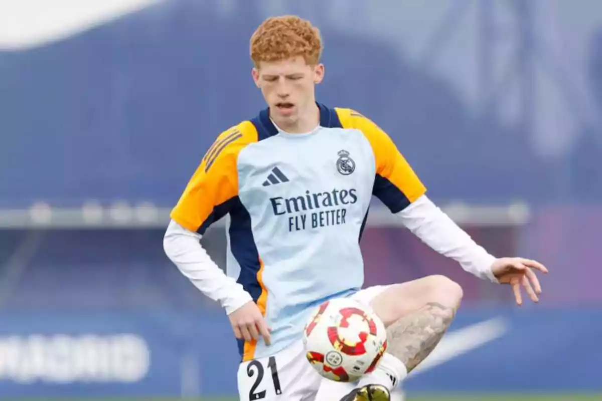 Futbolista con uniforme de entrenamiento del Real Madrid controlando un balón durante una práctica Futbolista con uniforme de entrenamiento del Real Madrid controlando un balón durante una práctica