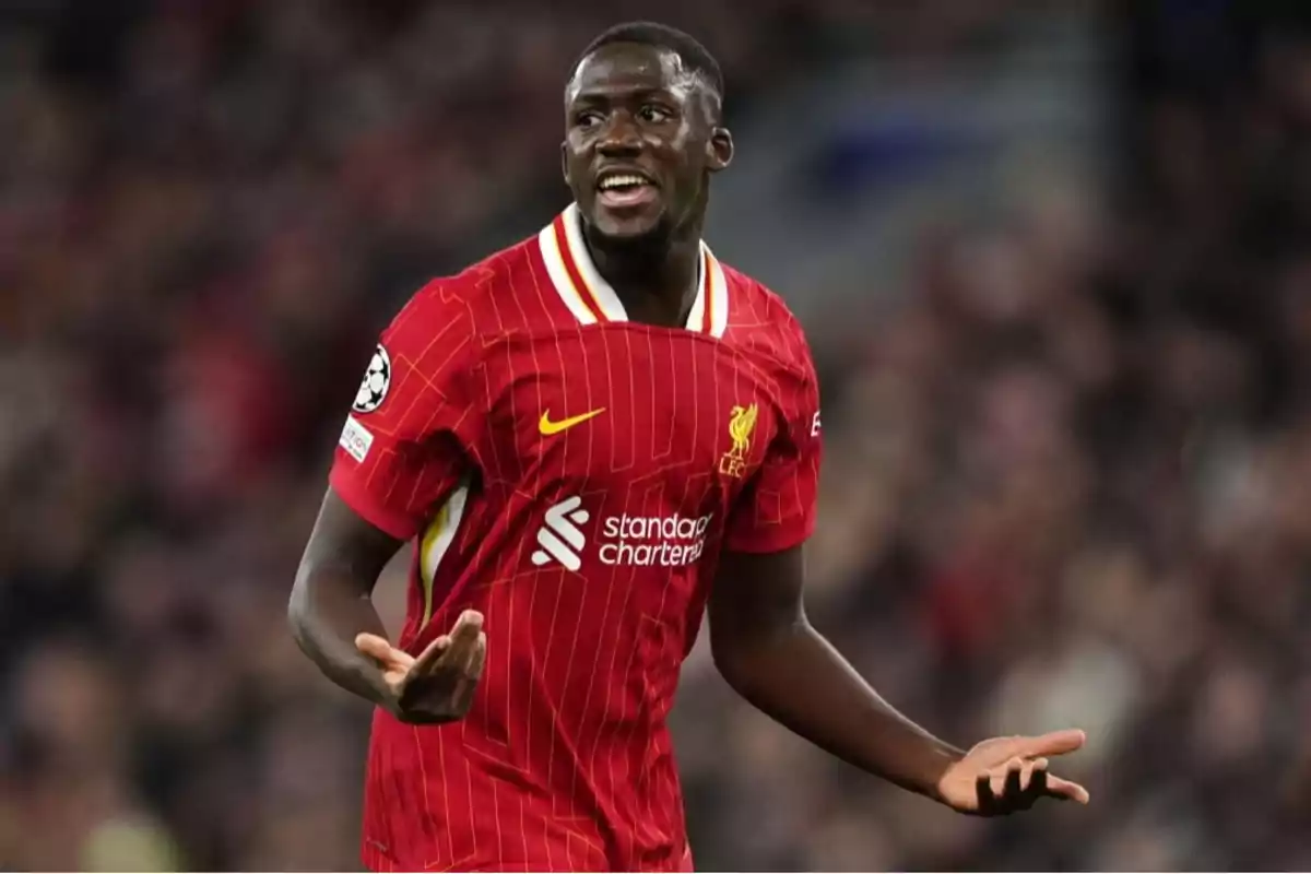 Soccer player in a red Liverpool uniform gesturing during a match Soccer player in a red Liverpool uniform gesturing during a match