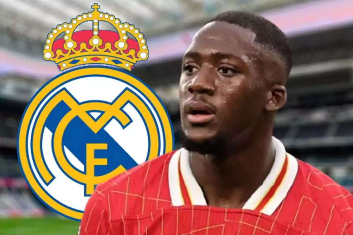 Soccer player wearing a red jersey in front of the Real Madrid crest in a stadium