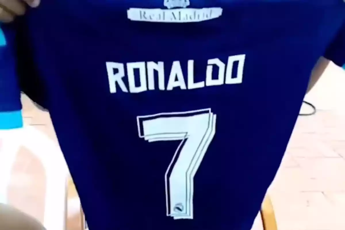 Blue Real Madrid jersey with the name Ronaldo and the number 7 on the back held by a person Blue Real Madrid jersey with the name Ronaldo and the number 7 on the back held by a person