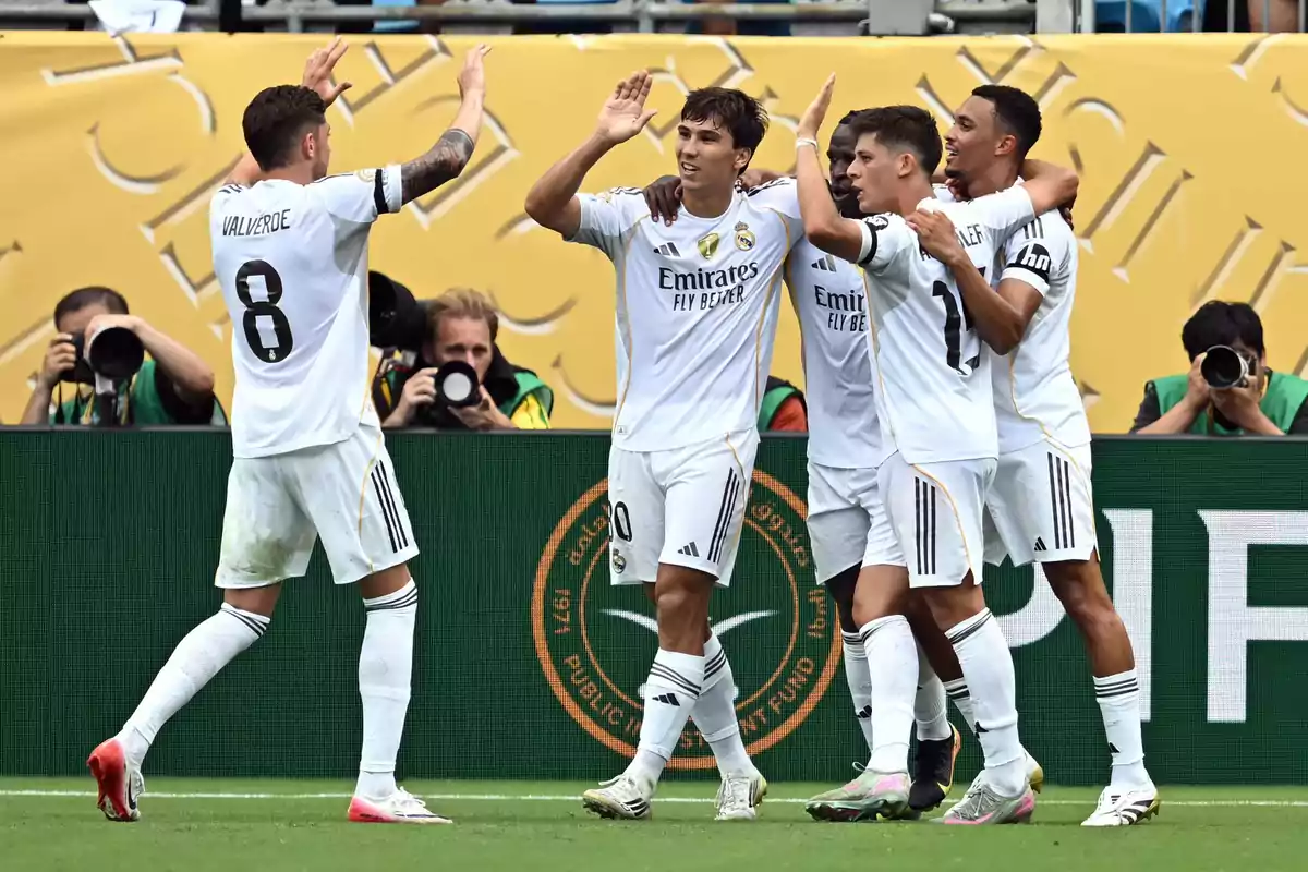 Real Madrid players celebrate a goal on the field while photographers capture the moment from the background. Real Madrid players celebrate a goal on the field while photographers capture the moment from the background.