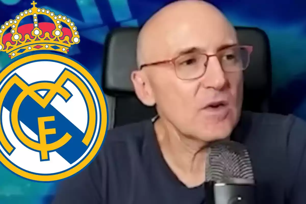 Bald man with glasses speaking in front of a microphone with the Real Madrid crest next to him