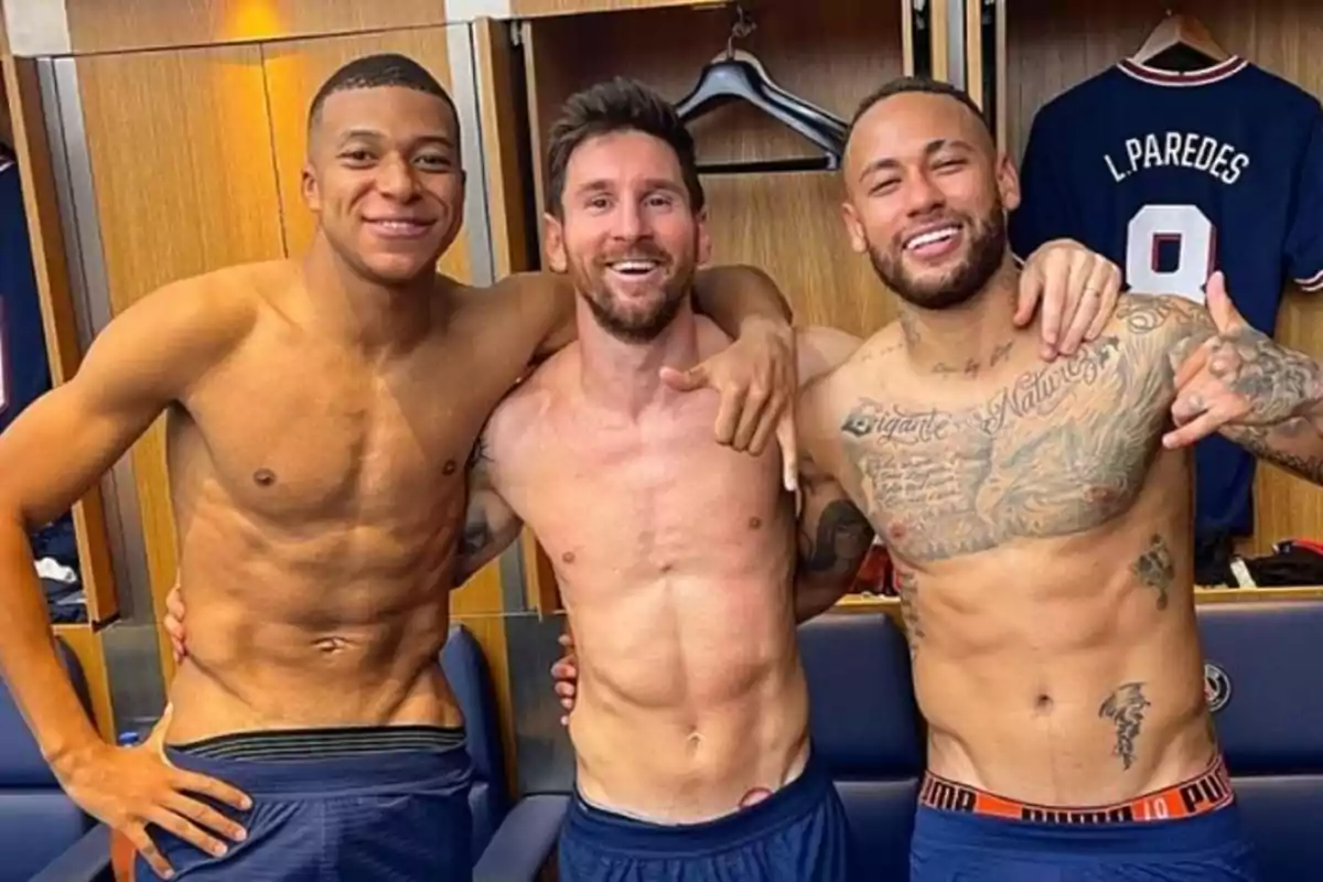 Tres futbolistas sonríen y posan sin camiseta en un vestuario Tres futbolistas sonríen y posan sin camiseta en un vestuario