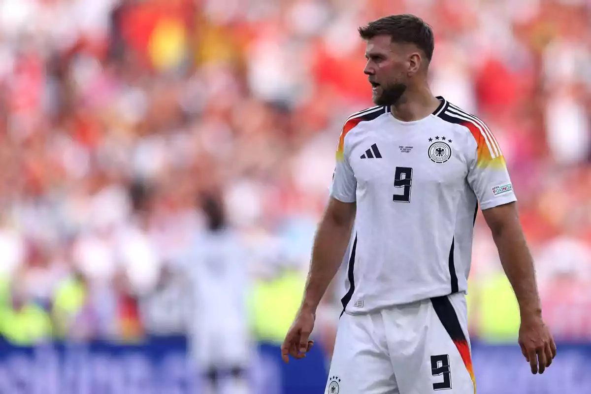 Futbolista con uniforme blanco de la selección de Alemania y el número 9 en el campo durante un partido Futbolista con uniforme blanco de la selección de Alemania y el número 9 en el campo durante un partido