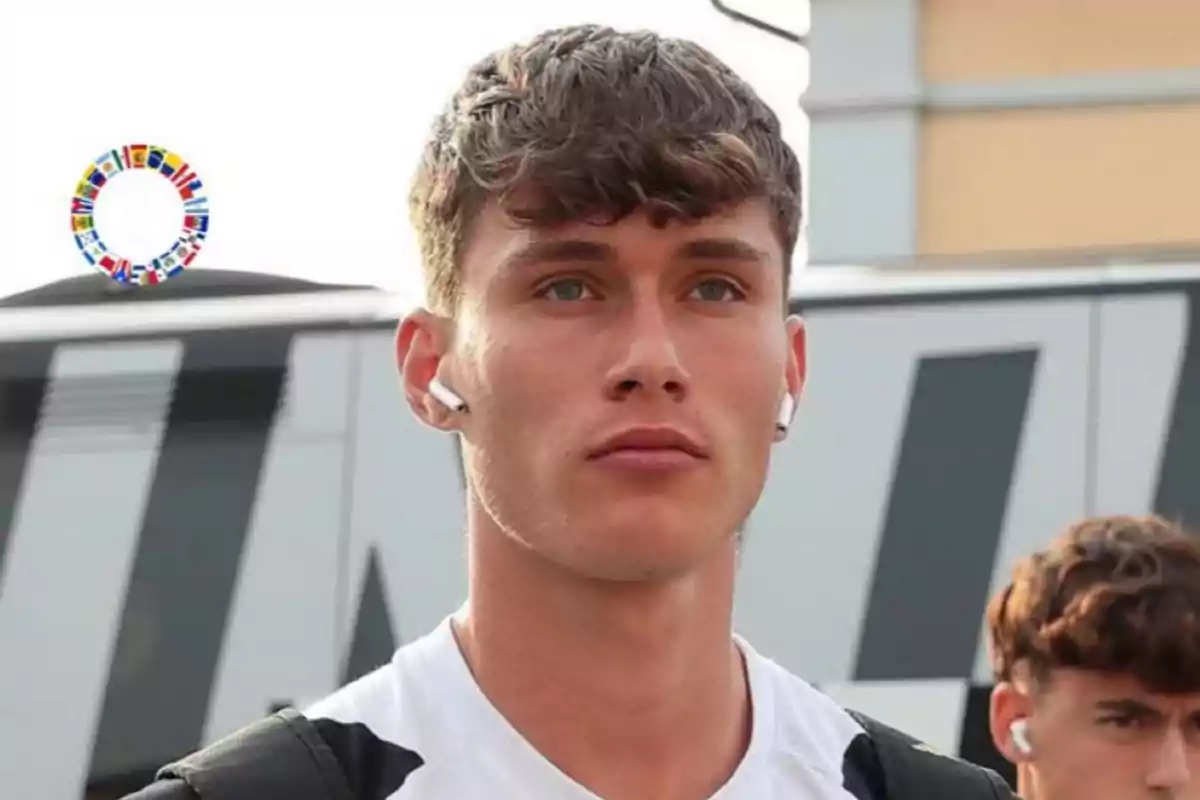 Young man with wireless headphones and a white t-jersey standing in front of a bus Young man with wireless headphones and a white t-jersey standing in front of a bus