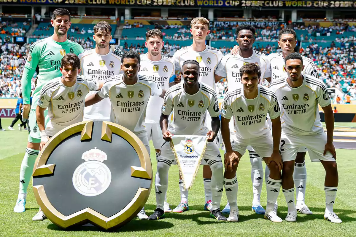 Real Madrid players pose for the official photo before a match at the stadium with the club crest in front.