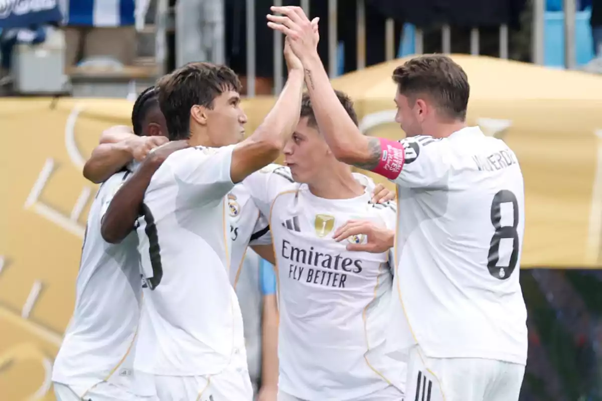 Jugadores del Real Madrid celebran un gol abrazándose en el campo durante un partido
