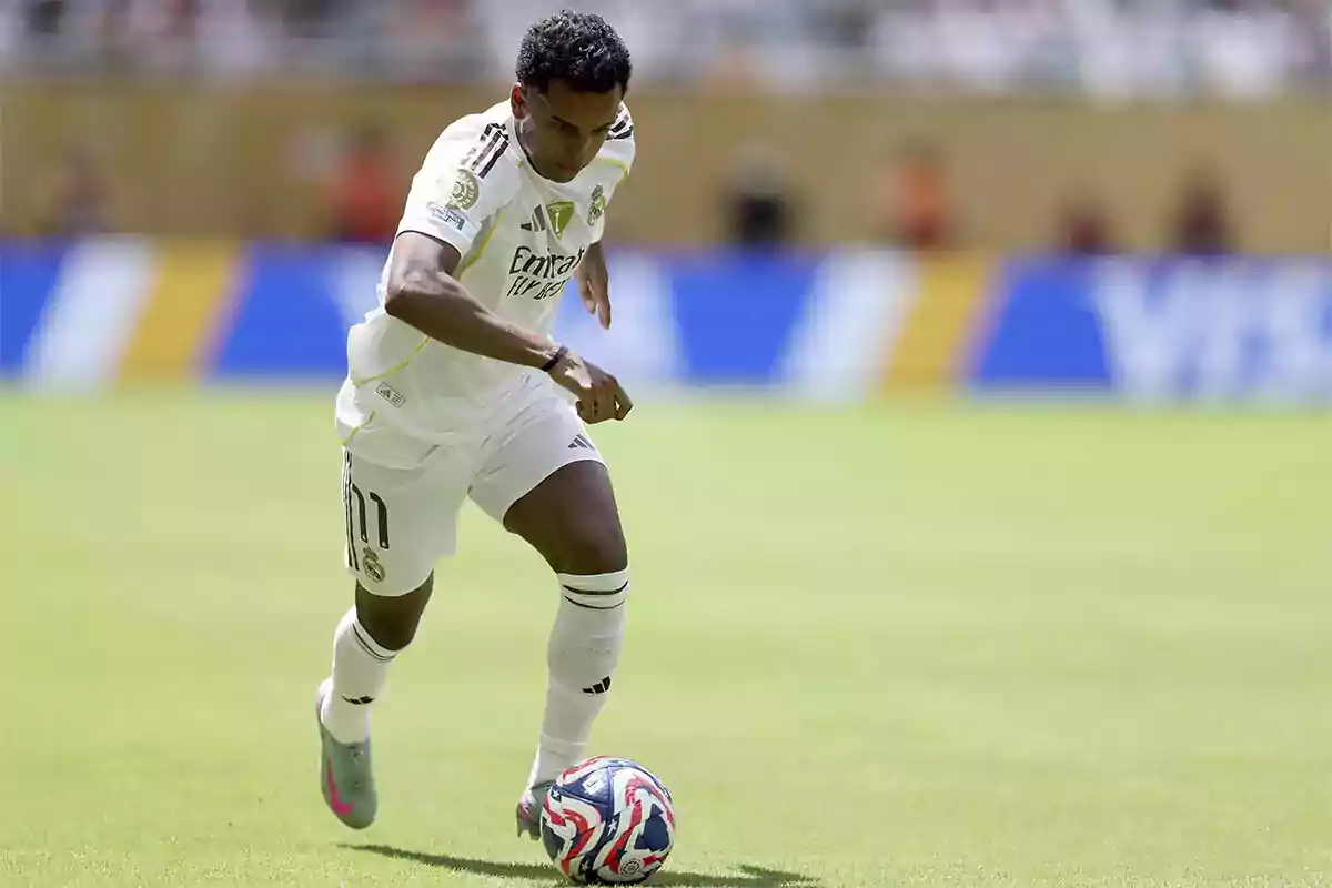 Real Madrid player controlling the ball during a match at an outdoor stadium Real Madrid player controlling the ball during a match at an outdoor stadium