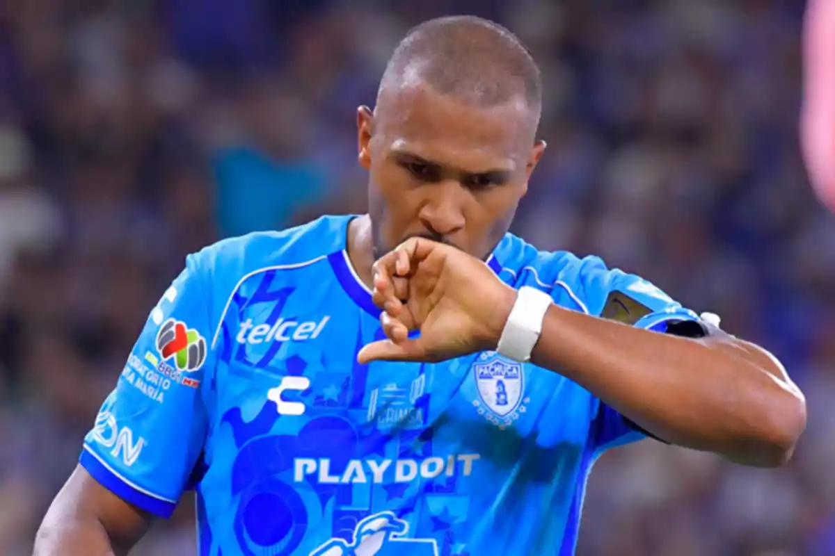 Futbolista con uniforme azul de Pachuca besando su puño en señal de celebración durante un partido Futbolista con uniforme azul de Pachuca besando su puño en señal de celebración durante un partido