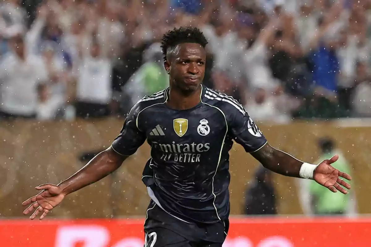 Real Madrid player celebrating a goal in the rain during a match with the crowd in the background