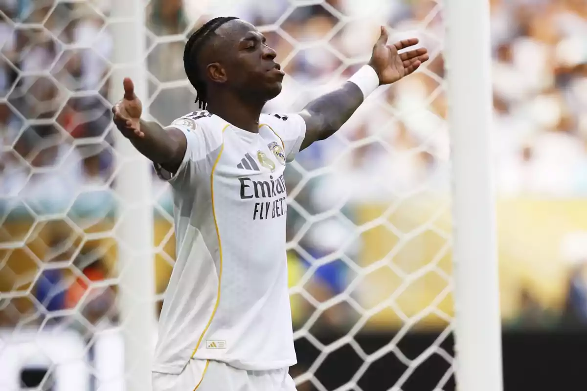 Real Madrid player celebrating a goal with arms outstretched in front of the goal