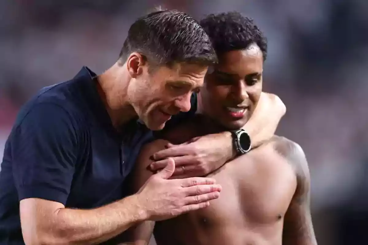 Entrenador abrazando y hablando con un futbolista sin camiseta en el campo Entrenador abrazando y hablando con un futbolista sin camiseta en el campo