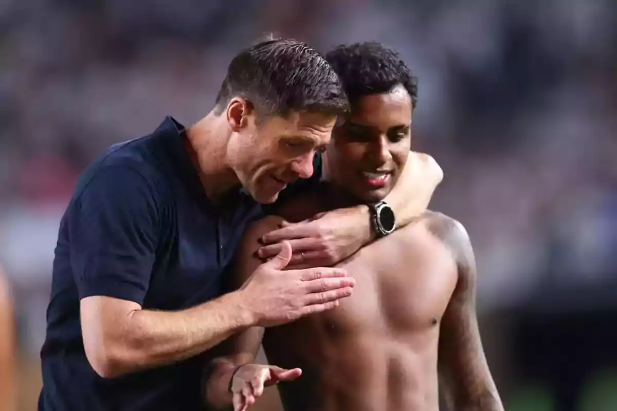 Coach hugs and motivates a jerseyless player on the field. Coach hugs and motivates a jerseyless player on the field.