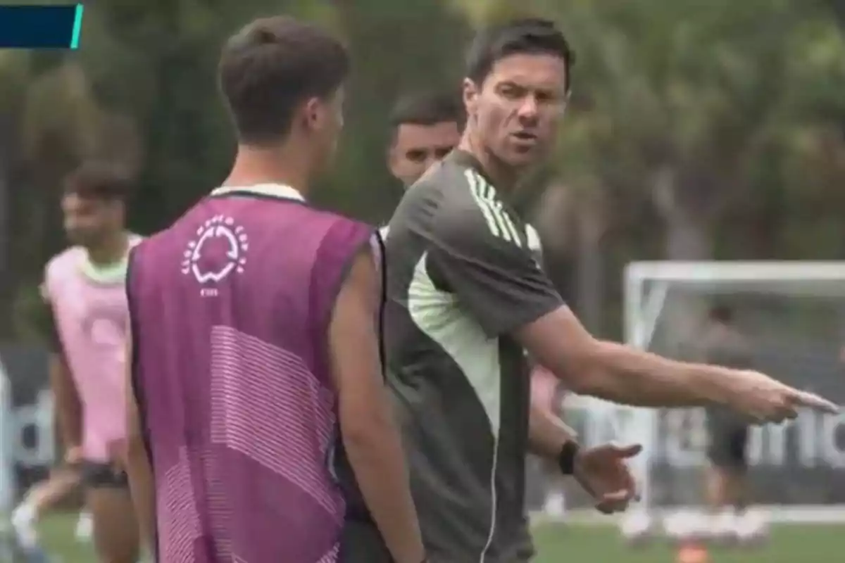 Soccer coach giving instructions to a player during a practice on the field