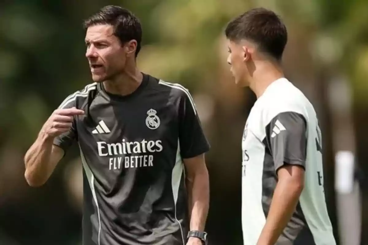 Real Madrid soccer coach giving instructions to a player during an outdoor training session Real Madrid soccer coach giving instructions to a player during an outdoor training session