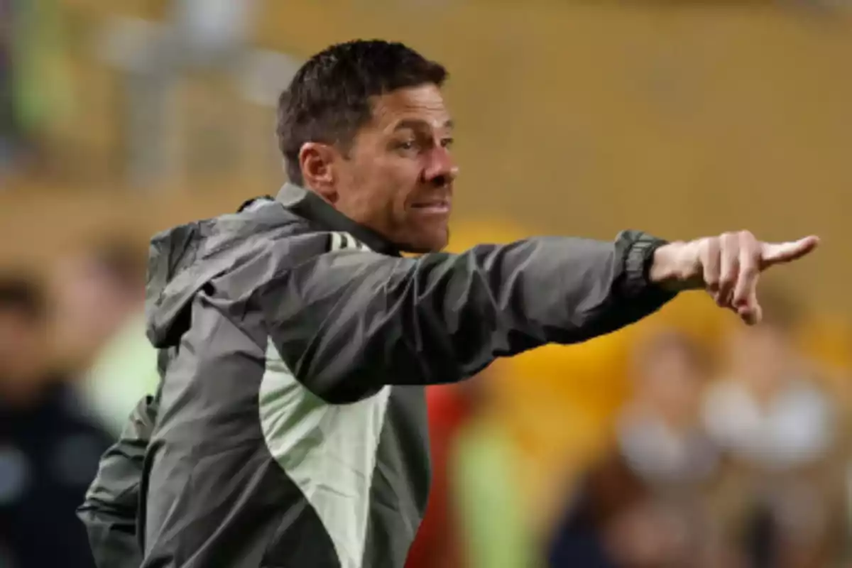 Entrenador de fútbol dando indicaciones en la cancha señalando con el brazo extendido Entrenador de fútbol dando indicaciones en la cancha señalando con el brazo extendido