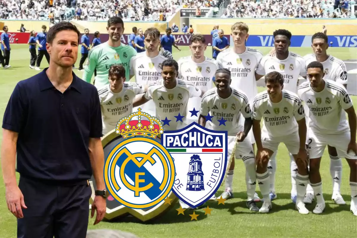 Coach standing next to a Real Madrid soccer team posing on the field with the Real Madrid and Pachuca crests in front.