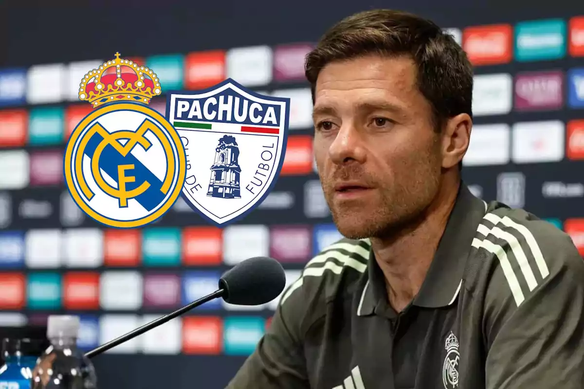 Man in a Real Madrid uniform at a press conference with the Real Madrid and Pachuca crests in the background