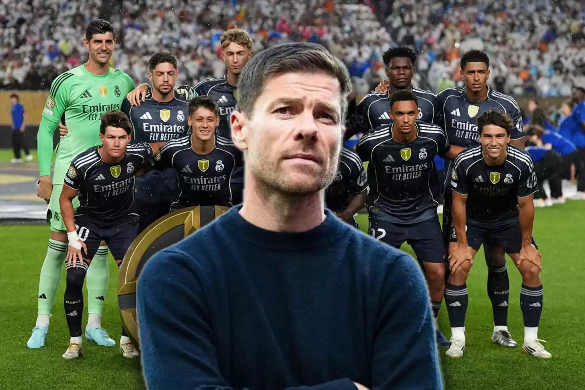 Un hombre en primer plano con expresión seria y al fondo un equipo de fútbol posando en la cancha con uniforme oscuro