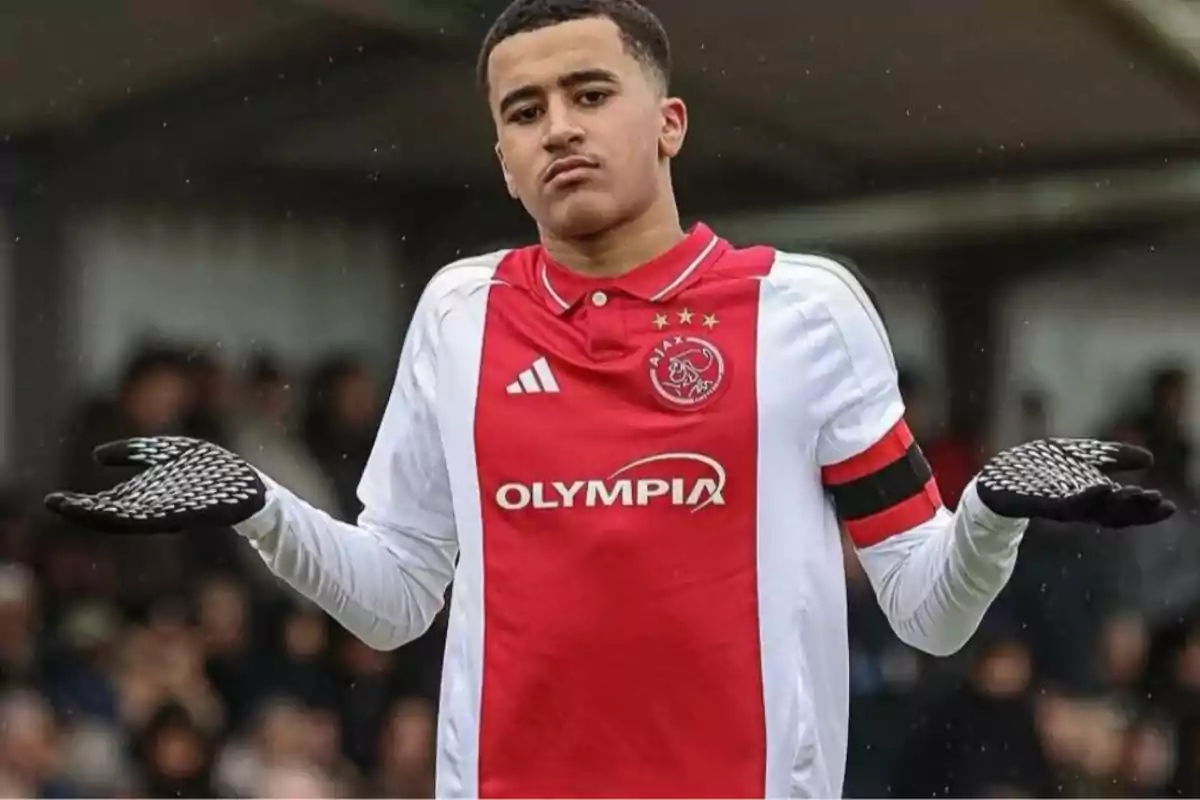 Soccer player in Ajax uniform shrugging during a match Soccer player in Ajax uniform shrugging during a match