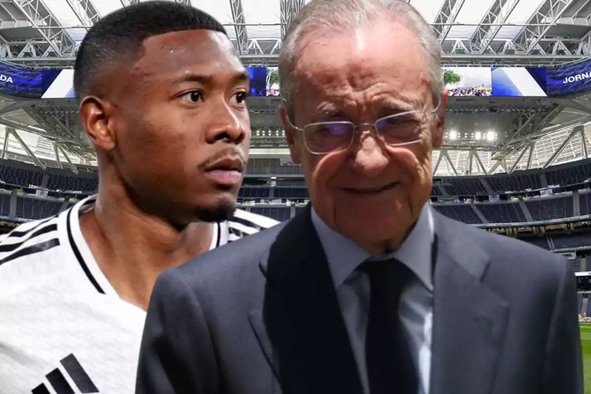 A player in a black and white uniform and an older man with glasses and a dark suit pose in a modern stadium.