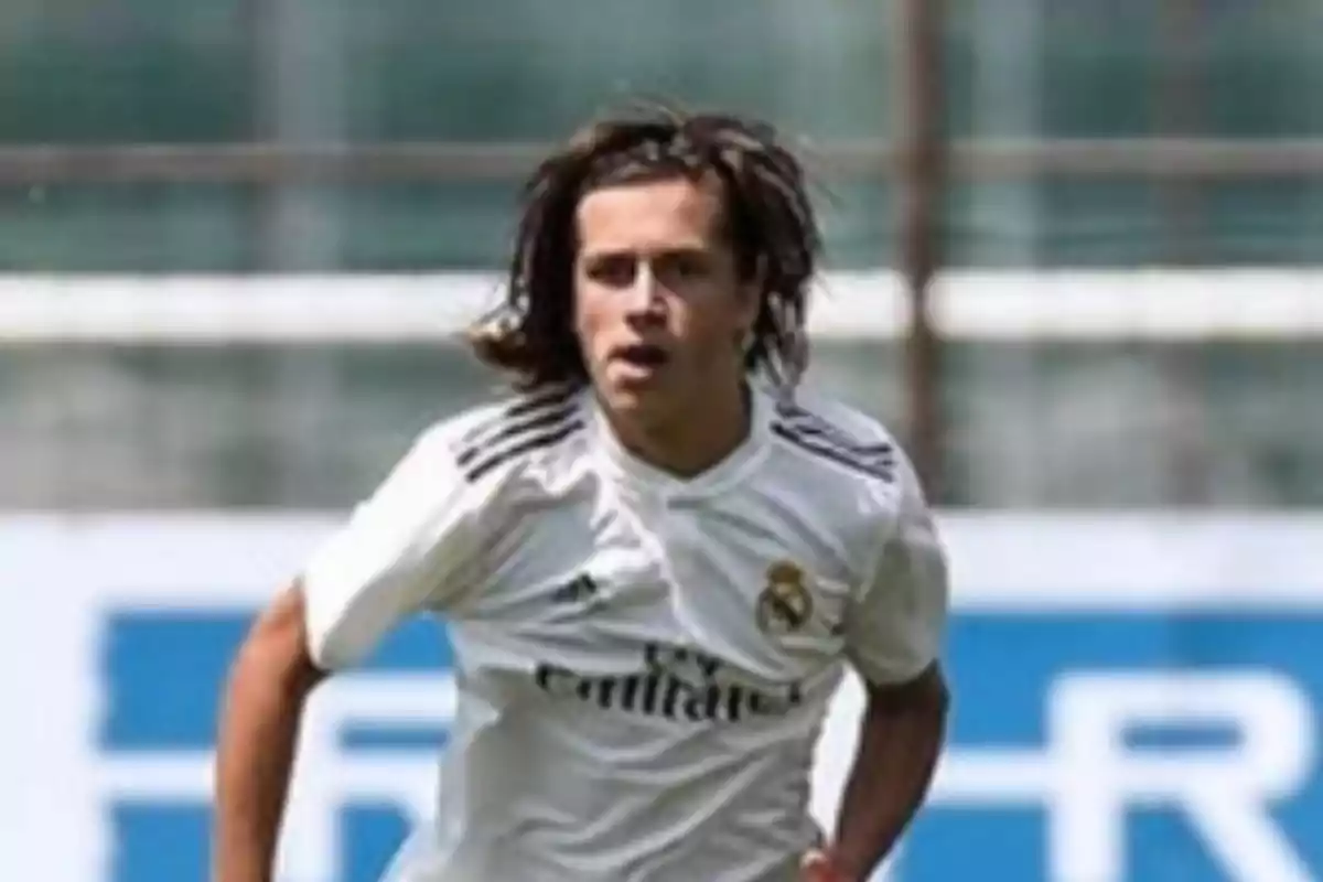 Soccer player with long hair wearing Real Madrid’s white uniform in a match Soccer player with long hair wearing Real Madrid’s white uniform in a match