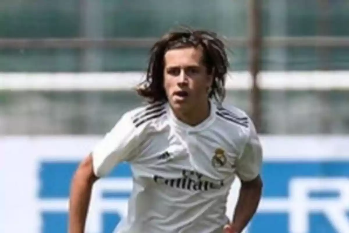 Young player wearing a white Real Madrid jersey running on the field during a match Young player wearing a white Real Madrid jersey running on the field during a match