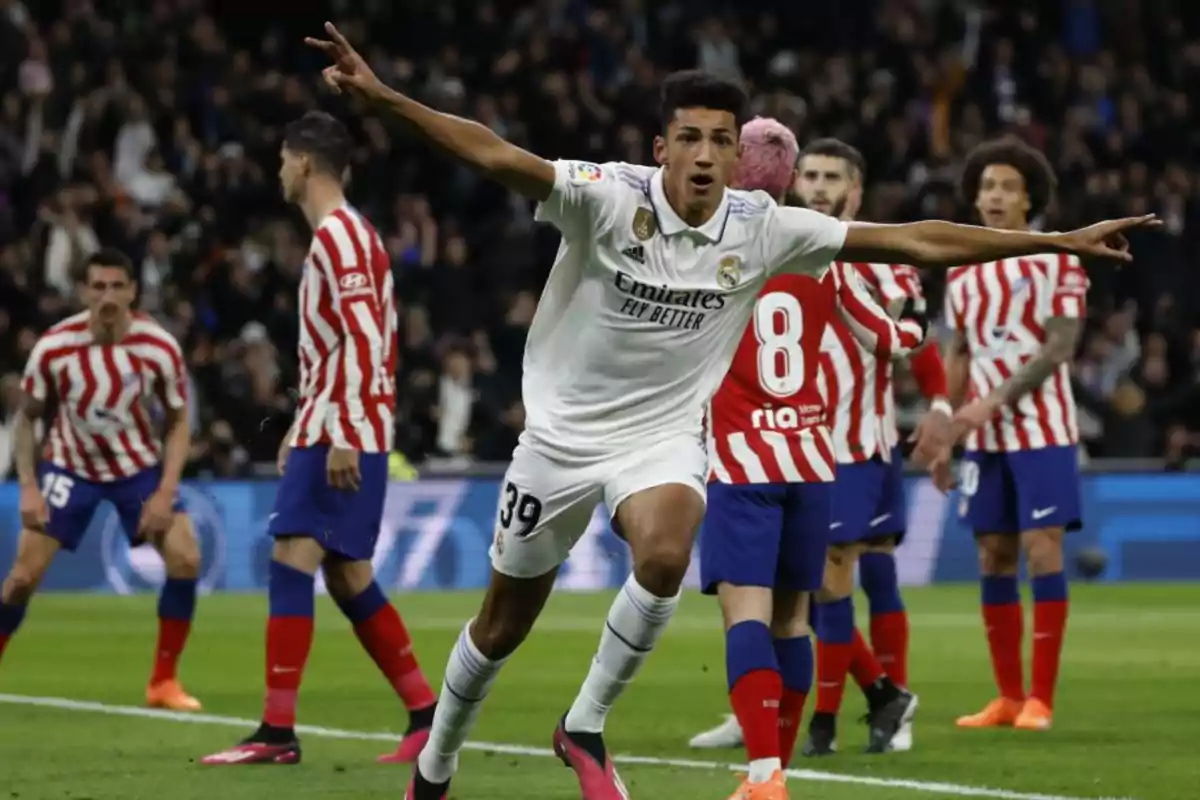 Jugador del Real Madrid celebrando un gol con los brazos extendidos mientras varios jugadores del Atlético de Madrid observan en el área Jugador del Real Madrid celebrando un gol con los brazos extendidos mientras varios jugadores del Atlético de Madrid observan en el área