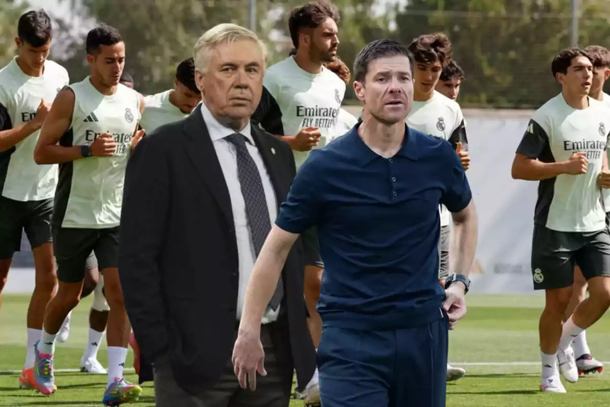 Soccer coaches in the foreground with Real Madrid players training on the field in the background