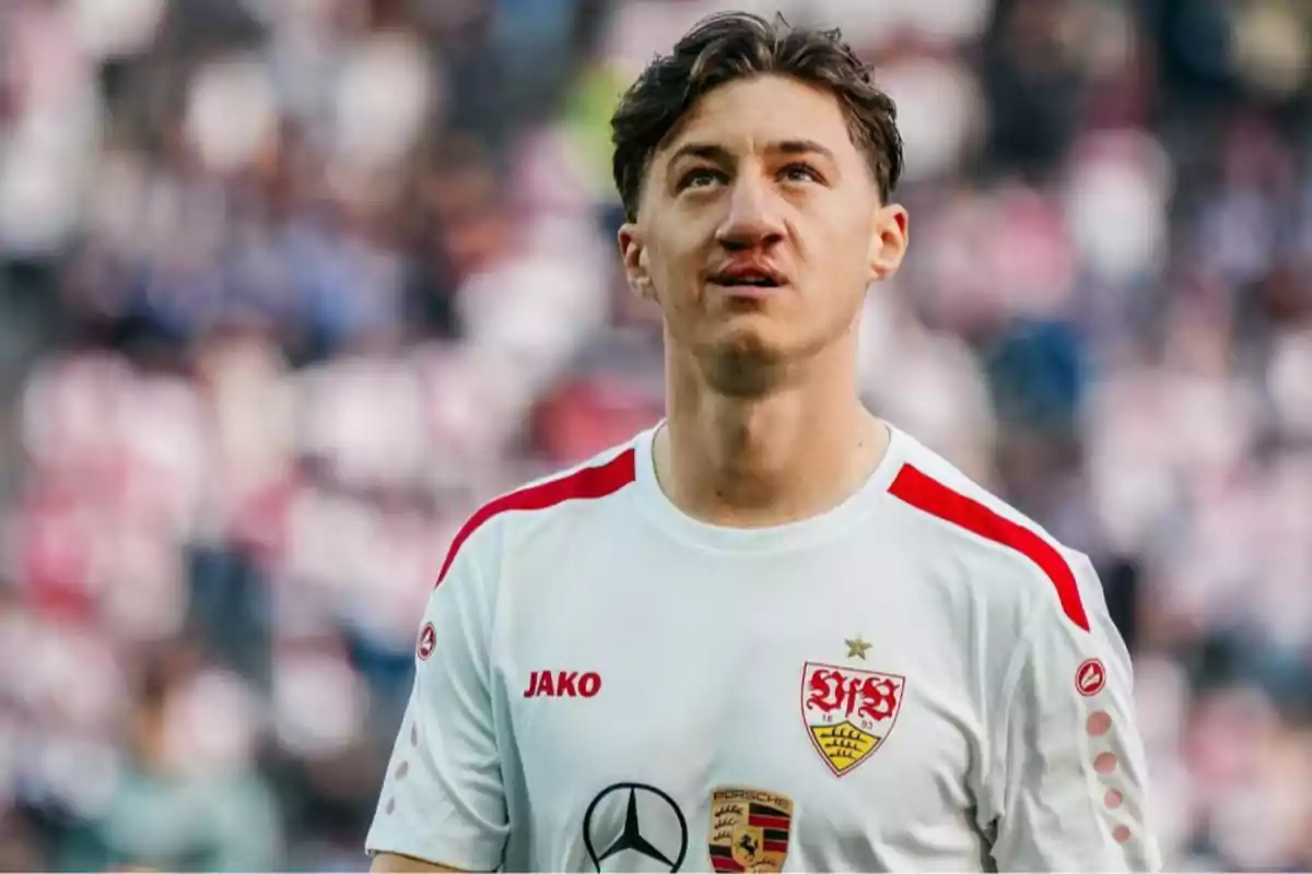 Jugador de fútbol con uniforme blanco del Stuttgart en un estadio lleno Jugador de fútbol con uniforme blanco del Stuttgart en un estadio lleno